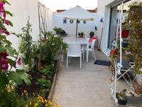 a patio with a white table and chairs and flowers at Appartement de 3 chambres a Les Sables d&#39;Olonne a 800 m de la plage avec wifi in Les Sables-d&#39;Olonne