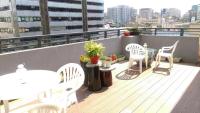 a balcony with a table and chairs on a roof at Taipei Discover Hostel in Taipei