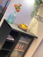 a refrigerator with a vase of flowers and a bowl of fruit at BIOTY CHILL &amp; SPA in Le Blanc-Mesnil