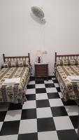 two beds in a room with a checkered floor at Pensión San Benito Abad in Seville