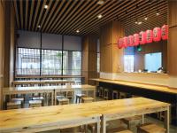 ein Restaurant mit Holztischen und Stühlen und einem Spiegel in der Unterkunft Hotel Osaka PIK2 in Tangerang