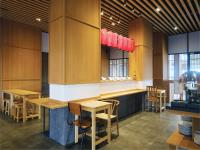 ein Restaurant mit Holzwänden und Tischen und Stühlen in der Unterkunft Hotel Osaka PIK2 in Tangerang