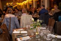 um grupo de pessoas sentadas numa mesa com copos de vinho em Hafsten Resort em Sundsandvik
