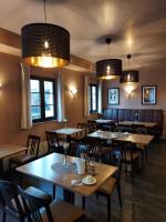 a restaurant with wooden tables and chairs and lights at Hotel Casa Rustica - Eintrittskarten für den Europapark erhalten Sie garantiert über uns! in Rust