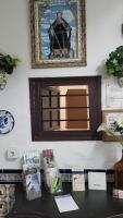 a mirror on a wall above a table with boxes at Pensión San Benito Abad in Seville