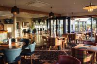 Un restaurante con mesas, sillas y ventanas. en Gwesty Gadlys Hotel, en Cemaes