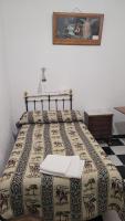 a bed with a quilt on it in a bedroom at Pensión San Benito Abad in Seville