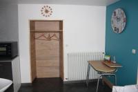 a room with a wooden door and a table and a clock at Gite De LA BALLADE in François