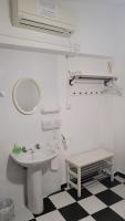 a white bathroom with a sink and a mirror at Pensión San Benito Abad in Seville