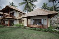a small house with a thatched roof at Qunci Villas Resort in Senggigi