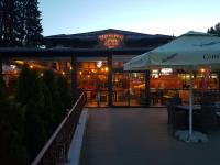 Un restaurante con mesas y sillas y una sombrilla. en Vila Predeal Holidays, en Predeal