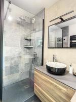 a bathroom with a sink and a glass shower at GRAND APPART TERRASSE PARKING DESIGN in Amiens