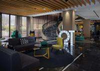 a living room with a couch and a spiral staircase at QT Canberra in Canberra