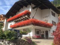 un edificio blanco con flores rojas. en Garni Le Chalet, en Santa Cristina Valgardena