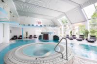 Una gran piscina con jacuzzi en un edificio. en Hotel Der Achtermann, en Goslar