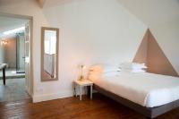 a bedroom with a large bed and a mirror at Manoir le Roure in Châteauneuf-du-Rhône