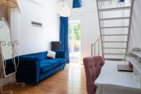 a living room with a blue couch and a ladder at Manoir le Roure in Châteauneuf-du-Rhône