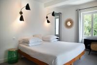 a bedroom with a large white bed and a window at Manoir le Roure in Châteauneuf-du-Rhône