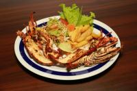 un plato de comida con camarones y ensalada y papas fritas en Coconut Primitive, en Negombo