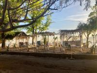 un parque con una valla, un edificio y árboles en Gili Air Santay Bungalows, en Gili Air