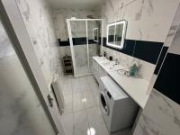 a bathroom with a sink and a washing machine at Appartement Prestige - Amiens in Amiens