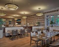 Un restaurante con mesas, sillas y lámparas de araña. en Four Seasons Resort Nevis, en Nevis