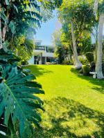 un patio verde con una casa al fondo en Casa Alfenapa a pie del lago y pet friendly, en Tequesquitengo