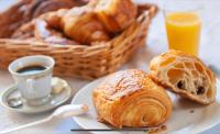 a plate of pastries and a cup of coffee and a basket of bread at Le soyeux in Lyon