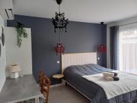 a bedroom with a bed with a blue wall at C La Belle Vie in Pessac