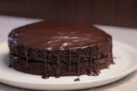 a chocolate cake sitting on a white plate at Tolip Olympia Hotel in Addis Ababa