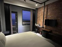a bedroom with a bed and a desk with a television at 窗外的海 - 海洋公園旁 in Yanliau
