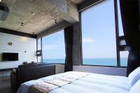 a bedroom with a large window with a large bed at 窗外的海 - 海洋公園旁 in Yanliau