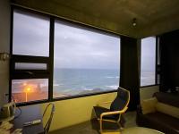 a room with a view of the ocean from a window at 窗外的海 - 海洋公園旁 in Yanliau