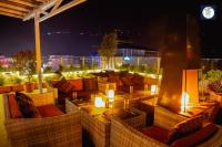 a rooftop patio with chairs and a fireplace at night at Himalayan Glory Inn in Pokhara