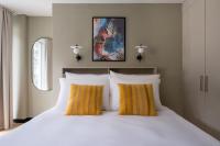 Un dormitorio con una gran cama blanca con almohadas amarillas. en Numa Zurich Craft, en Zúrich