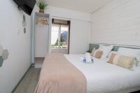 a bedroom with a large white bed with pillows at Hostellerie LE PANEL in Mandelieu-La Napoule