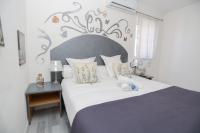 a bedroom with a large bed and a night stand at Hostellerie LE PANEL in Mandelieu-La Napoule