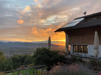 une maison avec un coucher de soleil en arrière-plan dans l&#39;établissement Hotel Dreiländerblick Dornbirn, à Dornbirn