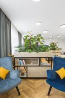 a living room with two blue chairs and plants at Hotel Restovna in Jíloviště