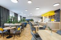 a restaurant with tables and chairs and plants at Hotel Restovna in Jíloviště