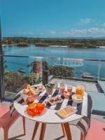 a table with food on it with a view of the water at Suítes Luxo Marambaia- Epic House in Rio de Janeiro