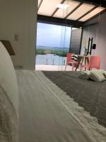 a bedroom with a bed with a view of the water at Suítes Luxo Marambaia- Epic House in Rio de Janeiro