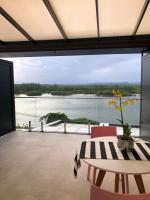 a dining room with a view of the water at Suítes Luxo Marambaia- Epic House in Rio de Janeiro