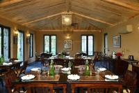 Aalia Jungle Retreat and Spa, Bandarjudh, Haridwar - Araiya Anthology في دهرادون: غرفة طعام مع طاولات وكراسي خشبية
