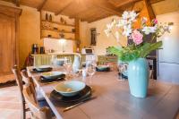 a table with a vase of flowers in a kitchen at MAISON YUKTI - Magnifique maison de charme proche plage in Lampaul-Ploudalmézeau