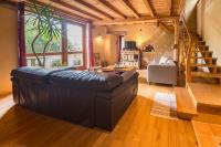 a large leather couch in a living room with a staircase at MAISON YUKTI - Magnifique maison de charme proche plage in Lampaul-Ploudalmézeau