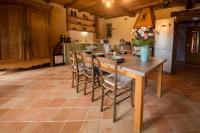 a kitchen with a wooden table with chairs and a refrigerator at MAISON YUKTI - Magnifique maison de charme proche plage in Lampaul-Ploudalmézeau