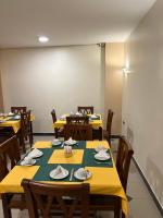 un comedor con mesas amarillas y sillas de madera en Anglo Hotel, en Luxor