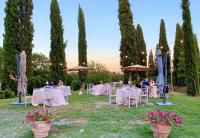 un ricevimento di nozze in giardino con tavoli e ombrelloni di Poggiovalle Tenuta Italiana a Città della Pieve