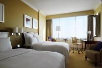 a hotel room with two beds and a desk at Warsaw Presidential Hotel in Warsaw